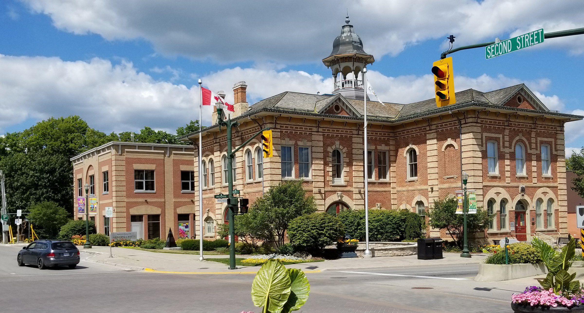 Orangeville's red-brick Town Hall, home of the Opera House, with buff-brick quoins, arched windows and a domed cupola, at the corner of Broadway and Second Street on a summer day