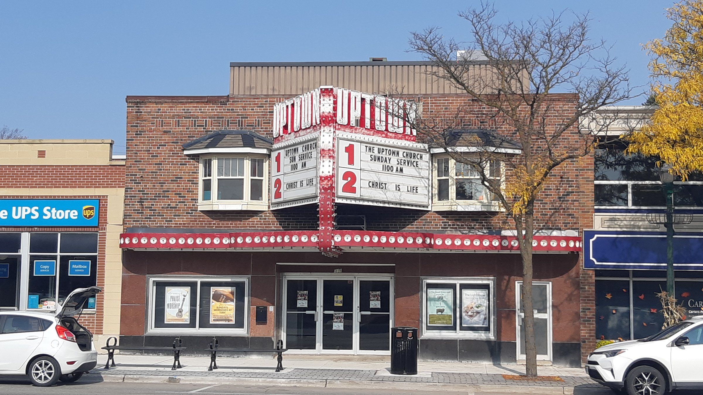 The Uptown Church in the former Uptown Theatre on Broadway, a brick front with two bay windows above a red-and-white cinema marquee announcing the church's Sunday service